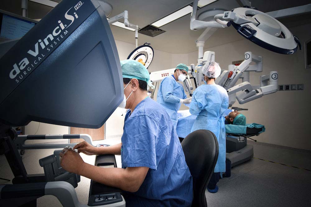 Tres médicos de Hospital Angeles realizando un procedimiento quirúrgico asistidos por el robot Da Vinci