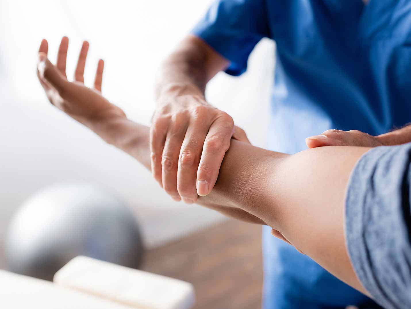 Fisioterapeuta ayudando a un paciente a realizar ejercicios de rehabilitación para su brazo izquierdo