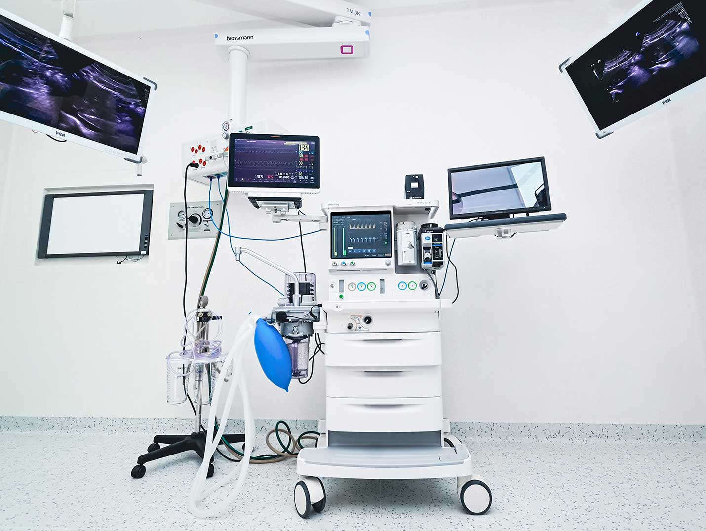 Equipo de anestesiología de ultima generación con pantallas encendidas dentro de un quirófano.