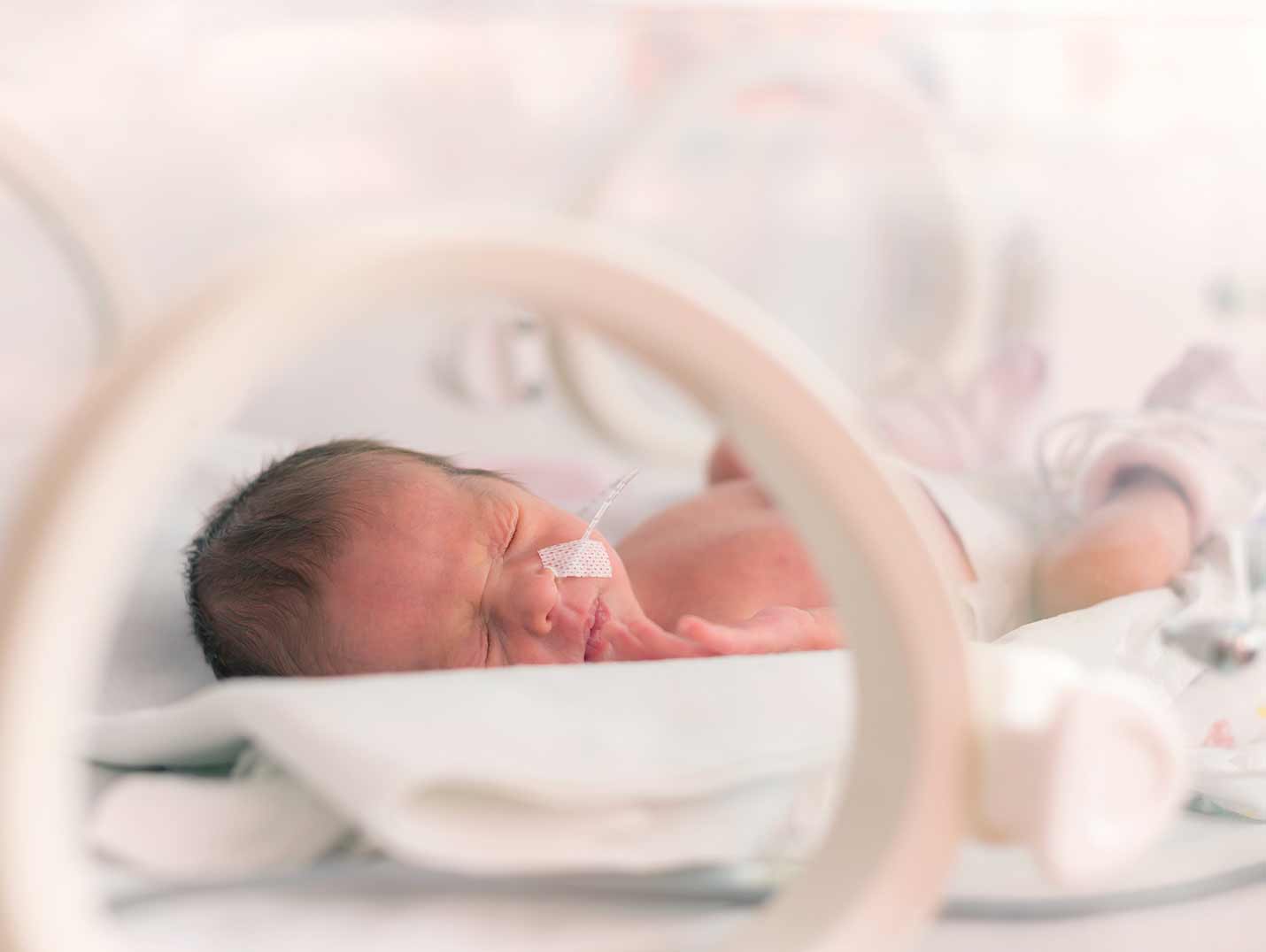 Bebé recién nacido dentro de una incubadora del área de cuidados intensivos neonatales
