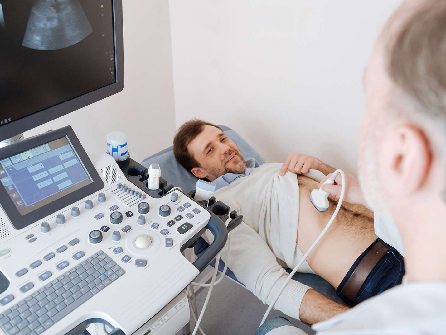 Doctor realizando un ultrasonido endoscópico a un paciente que está recostado en una camilla de observación