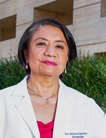 Es la foto de perfil de una dermatóloga en Ciudad de México de Hospital Angeles. está vestida con una bata blanca, y una blusa roja. Tiene un collar dorado y usa aretes largos en forma de gota de color blanco. Tiene el cabello de color negro.