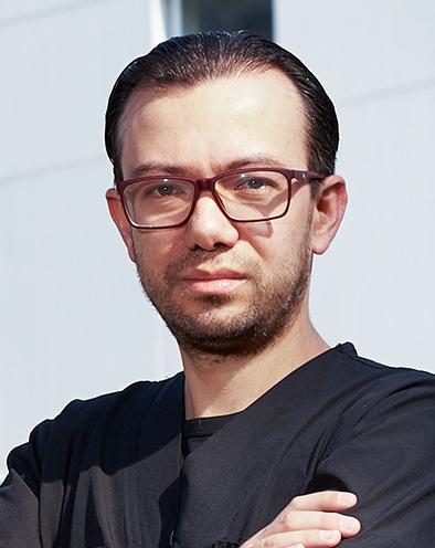 Es la foto de perfil de un cardiólogo en Ciudad de México de Hospital Angeles Lindavista. Tiene el cabello negro. Usa unos lentes rojos y un uniforme médico negro.