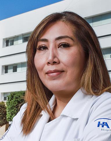 Es la foto de perfil de una ginecóloga y obstetra en Ciudad de México de Hospital Angeles. La doctora está sonriendo suavemente a la cámara, viste una bata blanca y su cabello es de color castaño claro.