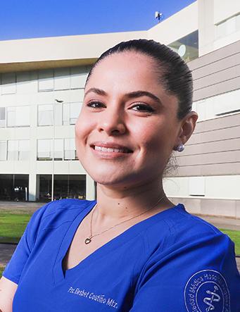 Es la foto de perfil de una psicóloga en Ciudad de México de Hospital Angeles. La doctora tiene un uniforme azul, con un collar dorado, está sonriendo y tiene de peinado un chongo.