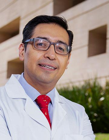 Es la foto de perfil de un pediatra en Ciudad de México de Hospital Angeles. Viste una bata blanca con camisa azul cielo y corbata roja.