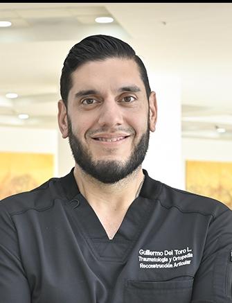 Es la foto de perfil de un ortopedista y traumatólogo en Ciudad Juárez de Hospital Angeles Ciudad Juárez. El doctor tiene un uniforme negro en cuello V, tiene barba y está sonriendo.