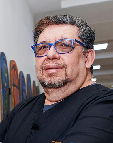 Es la foto de perfil de un pediatra en Ciudad de México de Hospital Angeles Lindavista. Tiene el cabello y barba gris con negro. Usa un uniforme médico negro.