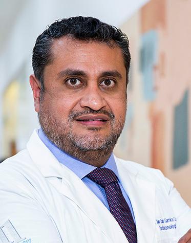 Es la foto de perfil de un endocrinólogo en Ciudad de México de Hospital Angeles Lindavista.Tiene el cabello negro y barba gris. Usa una bata blanca con una camisa azul claro y una corbata morada.