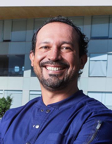 Es la foto de perfil de un cirujano general en Ciudad de México de Hospital Angeles. Viste una chamarra azul , tiene barba y está sonriendo.