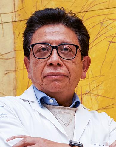 Es la foto de perfil de un neurólogo en Ciudad de México de Hospital Angeles Lindavista.Tiene el cabello negro. Usa bara blanca con un sueter café claro, una camisa azul claro y lentes.