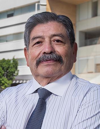 Es la foto de perfil de un cirujano neurológico en Ciudad de México de Hospital Angeles. Viste una camisa blanca con líneas verticales grises y azules. Tiene una corbata.