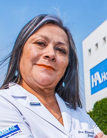 Es la foto de perfil de una dermatóloga en Ciudad de México de Hospital Angeles Lindavista. Tiene el cabello corto y gris. Usa una bata blanca.