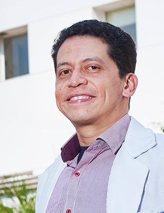 Es la foto de perfil de un endocrinólogo en Ciudad de México de Hospital Angeles Lindavista. Tiene el cabello negro. Está sonriendo. Usa una bata blanca y una camisa rosa.