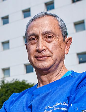 Es la foto de perfil de un ortopedista y traumatólogo en Ciudad de México de Hospital Angeles Lindavista. Tiene el cabello gris. Usa un uniforme médico azul. Está sonriendo.