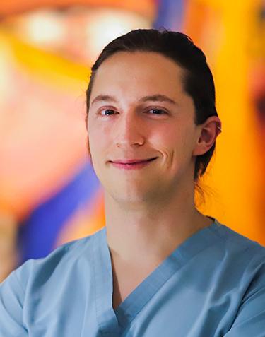 Es la foto de perfil de un oftalmólogo en Ciudad de México de Hospital Angeles. Usa un uniforme azul cielo, es de tez blanca y está sonriendo.