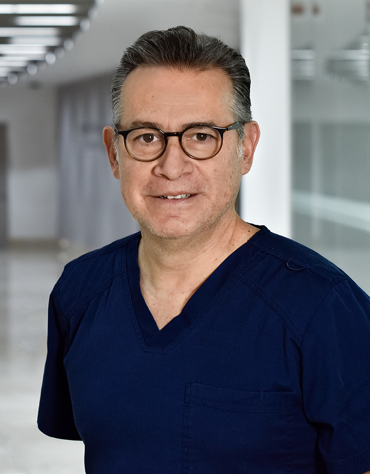 Es la foto de perfil de un ortopedista y traumatólogo en Huixquilucan. Tiene el cabello negro. Usa lentes  y un uniformr médico azul oscuro.