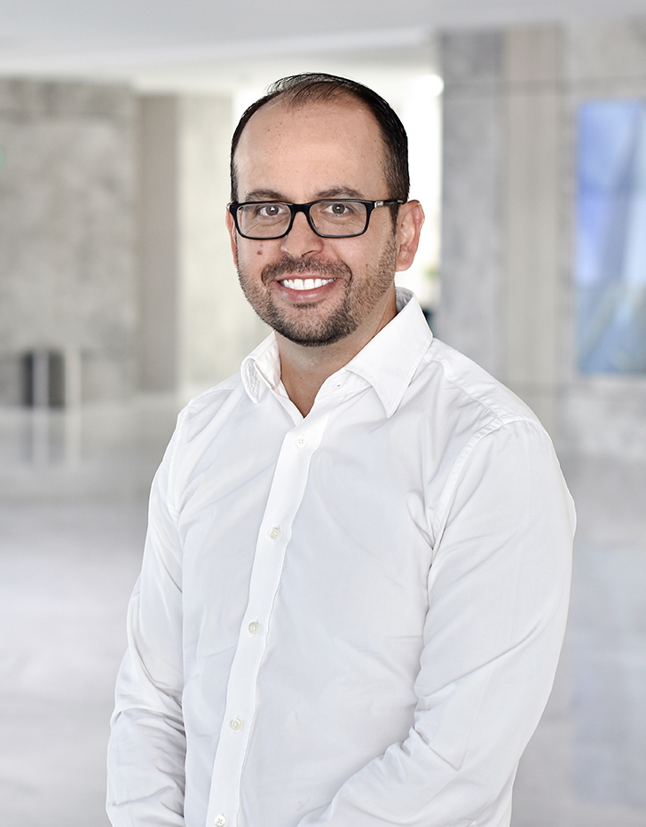 Es la foto de perfil de un hematólogo en Querétaro de Hospital Angeles Centro Sur. Usa una camisa blanca, está sonriendo y tiene lentes.