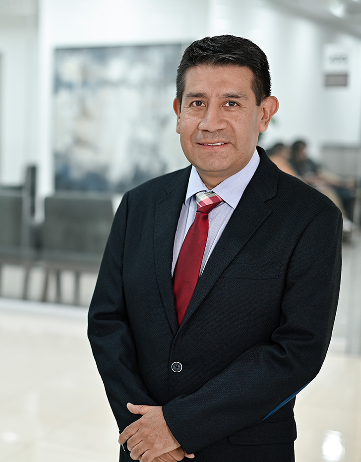 Es la foto de perfil de un endoscopista y cirujano general en Ciudad de México de Hospital Angeles. Es la imagen de un doctor con un estetoscopio en la mano izquierda, figurando que se toma el codo del brazo derecho, la fotografía está tomada en un cuarto del cuerpo del doctor. 