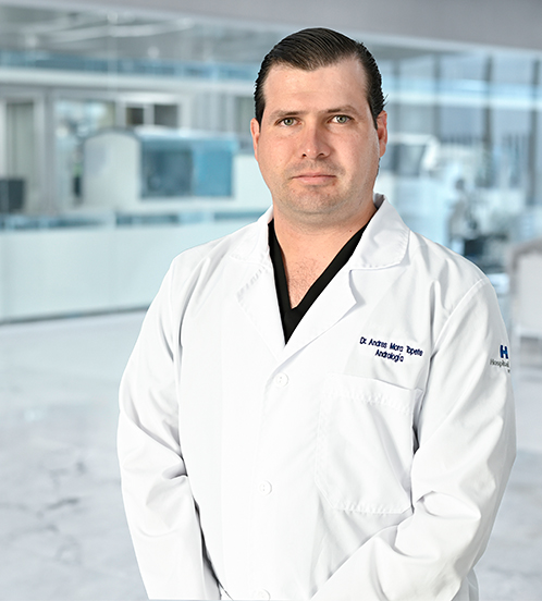 Es la foto de perfil de un médico general en Guadalajara de Hospital Angeles Del Carmen.Usa un uniforme médico color negro. Tiene poco cabello color negro. Tiene los brazos cruzados por detrás y está sonriendo ligeramente.