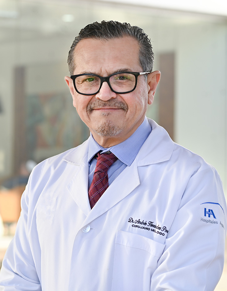 Es la foto de perfil de un urólogo en Tijuana de Hospital Angeles Tijuana. Usa una bata blanca, lentes y una corbata roja. Tiene bigote y está sonriendo.