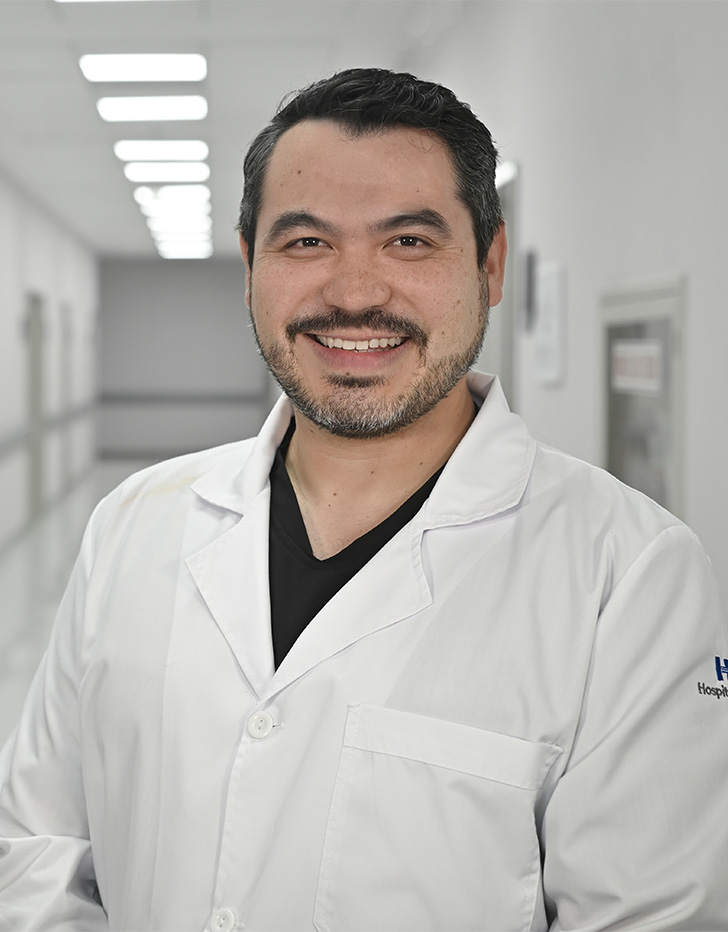 Es la foto de perfil de un cirujano neurológico en Ciudad de México de Hospital Angeles Universidad. Usa una bata blanca. Tiene bigote y cabello negro.