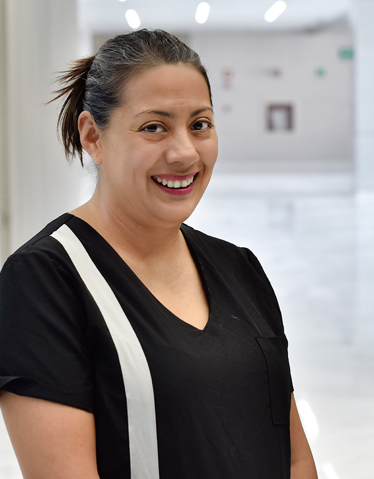 Es la foto de perfil de una hematóloga pediátrica en Querétaro de Hospital Angeles Centro Sur. Viste un uniforme negro con una franja blanca de lado su lado derecho, está sonriendo y tiene el cabelo recojido.