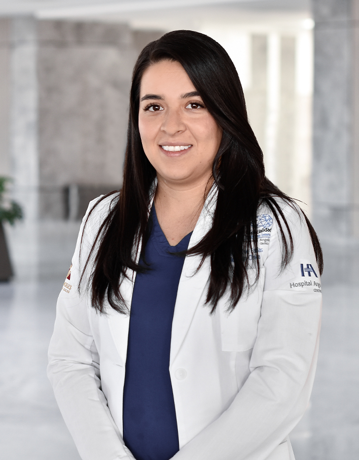 Es la foto de perfil de una nutrióloga en Querétaro de Hospital Angeles Centro Sur. Viste una bata blanca y una playera azul marino, está sonriendo.