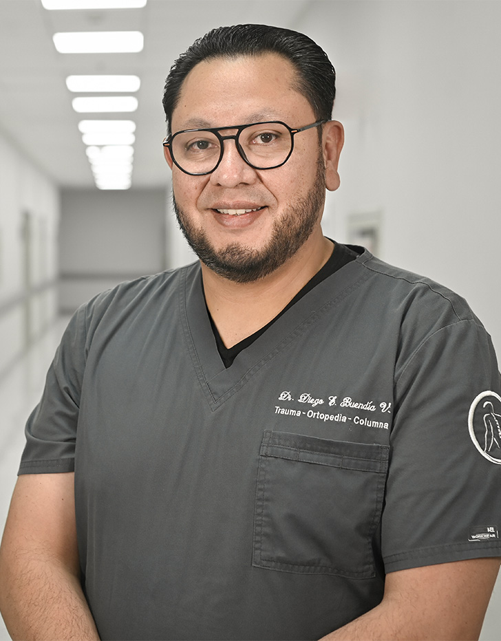 Es la foto de perfil de un ortopedista, traumatólogo y especialista en artoscopía en Ciudad de México de Hospital Angeles Universidad. Usa un uniforme médico color gris y lentes. Tiene el cabello y barba negro.