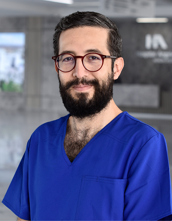 Es la foto de perfil de un gastroenterólogo en Querétaro de Hospital Angeles Centro Sur. Tiene barba y lentes, y usa un uniforme azul.