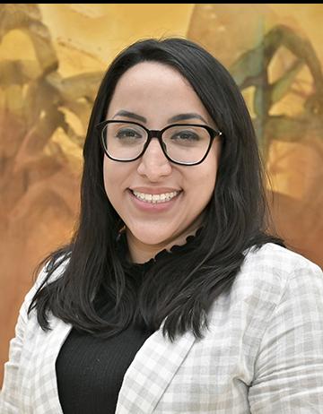 Es la foto de perfil de una nefróloga en Ciudad Juárez de Hospital Angeles Ciudad Juárez. Usa un traje gris con cuadros y blusa negra. Tiene lentes y cabello negro.