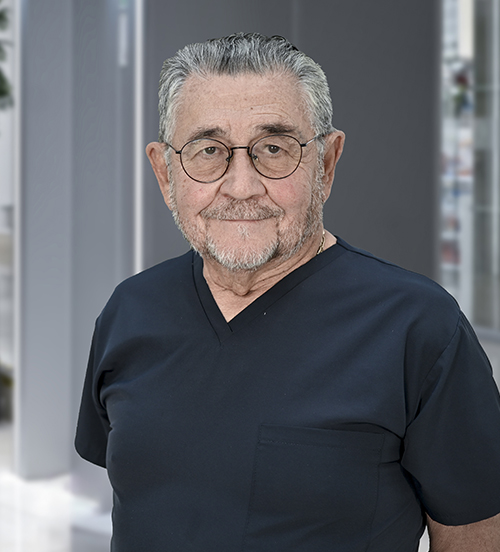 Es la foto de perfil de un ortopedista y traumatólogo en Huixquilucan de Hospital Angeles Lomas. Usa una bata blanca con camisa, tiene los brazos cruzados y el cabello canoso.