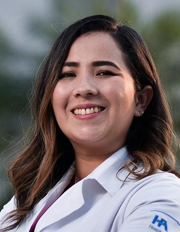 Es la foto de perfil de una especialista en medicina crítica pediátrica y pediátra en Villahermosa de Hospital Angeles Villahermosa. Usa una bata blanca. Tiene el cabello café y ondulado. Tiene los brazos cruzados y está sonriendo.