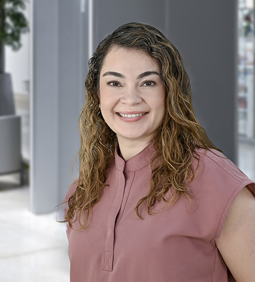 Es la foto de perfil de una genetista en Huixquilucan de Hospital Angeles Lomas. Usa una bata blanca con un suéter de cuello de tortuga, su cabello es ondulado y claro.