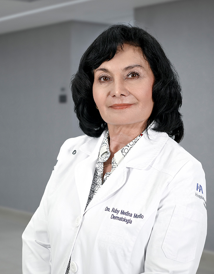 Es la foto de perfil de una dermatóloga en Ciudad de México de Hospital Angeles Lindavista.Usa una bata blanca y un suéter de cuello alto rojo.