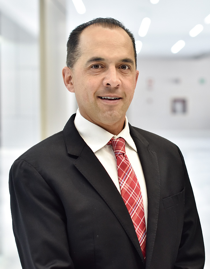 Es la foto de perfil de un biólogo de la reproducción en Querétaro de Hospital Angeles Centro Sur. Viste un traje negro con camisa blanca y corbata roja.