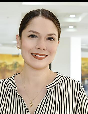 Es la foto de perfil de una cirujana cardiotorácica en Ciudad Juárez de Hospital Angeles Ciudad Juárez. Viste una blusa blanca con rayas verticales negras. Tiene el cabello recogido y es de color negro.