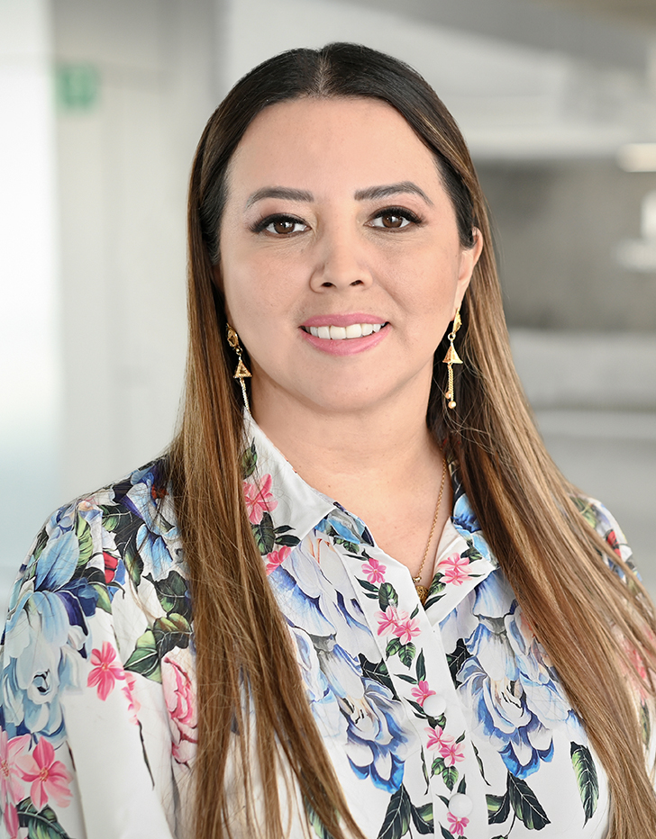 Es la foto de perfil de una ginecóloga y obstetra en Querétaro de Hospital Angeles Centro Sur. Blusa blanca con flores azules y rosas, tiene el cabello largo.