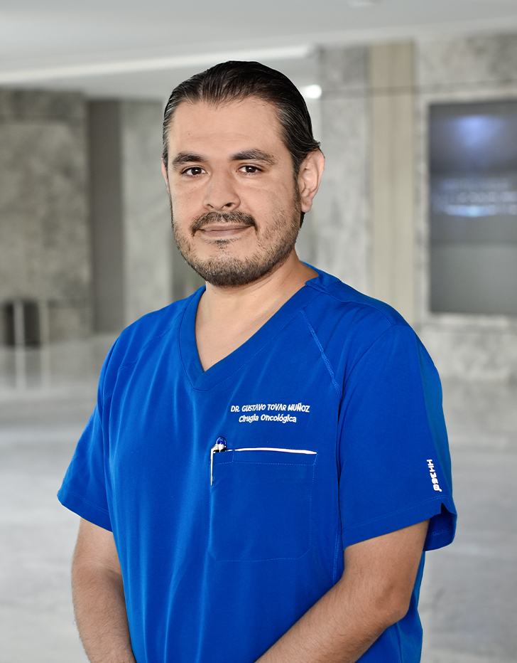 Es la foto de perfil de un gastroenterólogo en Querétaro de Hospital Angeles Centro Sur. Tiene un uniforme color azul y de fondo está en la recepción del hospital.