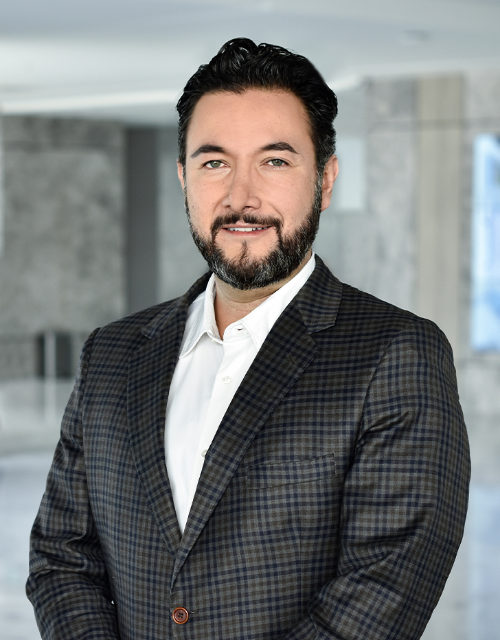 Es la foto de perfil de un anestesiólogo en Querétaro de Hospital Angeles Centro Sur. Viste un traje negro con cuadros azul marino, una camisa blanca, tiene barba y ojos verdes.