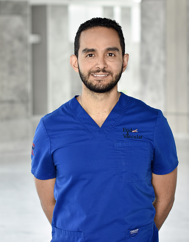 Es la foto de perfil de un neumólogo pediátrico en Querétaro de Hospital Angeles Centro Sur. Usa un uniforme azul, tiene una cadena plateada y está sonriendo.