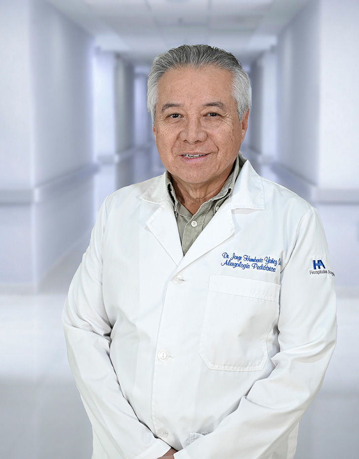 Es la foto de perfil de un alergólogo pediátrico en Ciudad Juárez de Hospital Angeles Ciudad Juárez. El doctor viste una bata blanca, camisa y tiene los brazos cruzados.