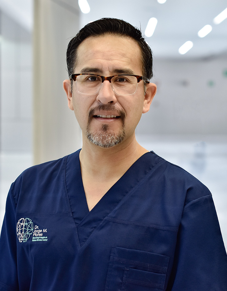 Es la foto de perfil de un cirujano neurológico en Querétaro de Hospital Angeles Centro Sur. está usando un uniforme azul marino con cuello V y lentes.