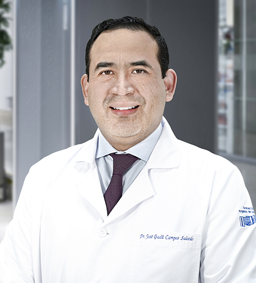 Es la foto de perfil de un urólogo en Huixquilucan de Hospital Angeles Lomas. Usa una bata blanca, está sonriendo y tiene corbata.