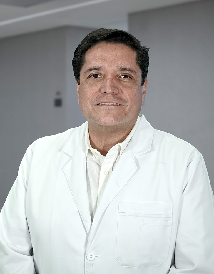 Es la foto de perfil de un urólogo en Ciudad de México de Hospital Angeles Lindavista. Tiene el cabello negro. Usa un saco color gris con líneas azules y una corbata azul de cuadros.
