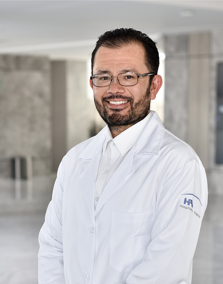 Es la foto de perfil de un radio-oncólogo en Querétaro de Hospital Angeles Centro Sur. Usa bata blanca con camisa blanca y lentes.