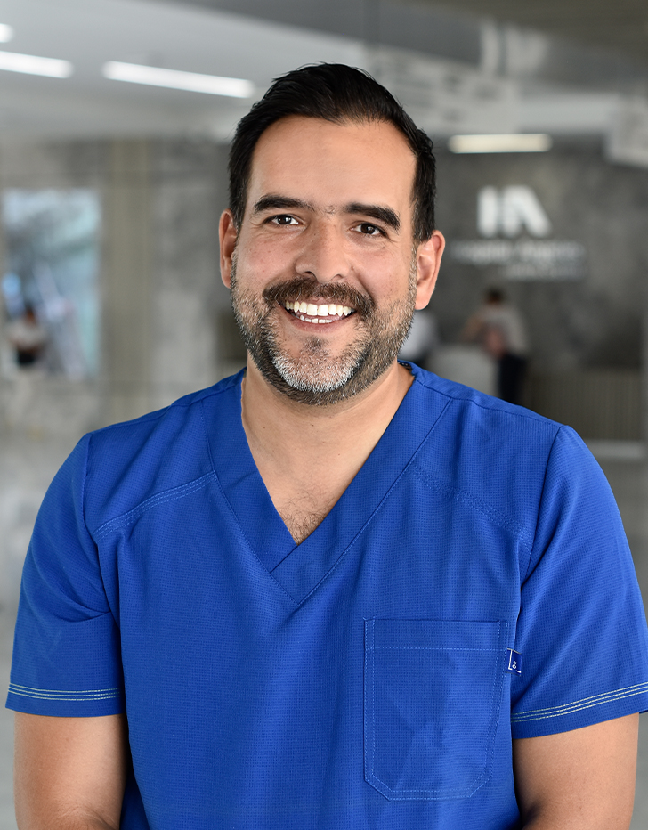 Es la foto de perfil de un cardiólogo pediátrico en Querétaro de Hospital Angeles Centro Sur. Usa un uniforme azul y tiene barba.