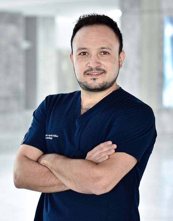 Es la foto de perfil de un urólogo en Querétaro de Hospital Angeles Centro Sur. Usa un uniforme azul marino y una cadena gruesa plateada.