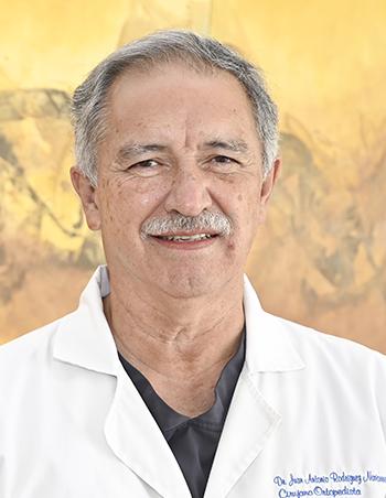 Es la foto de perfil de un ortopedista y traumatólogo en Ciudad Juárez de Hospital Angeles Ciudad Juárez. El doctor tiene el cabello y el bigote canoso, está sonriendo y utiliza una bata blanca.