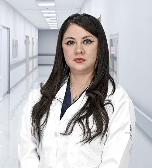 This is the profile photo of a pediatrician México  Hospital Angeles Universidad México City. He is wearing a pink medical uniform. He has straight, dark brown hair. He is smiling and has his arms crossed behind his back.